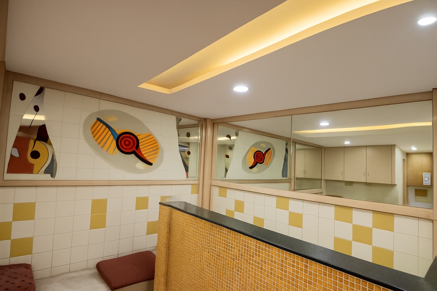 Mosaic artwork and mirrors above the lobby counter