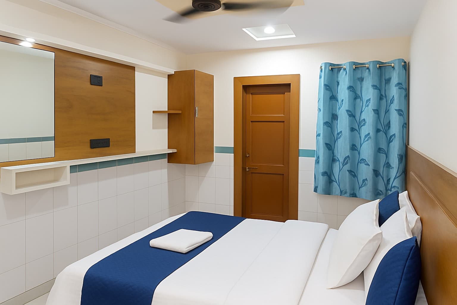 Budget Room — double bed with ceiling fan, wardrobe and tiled walls